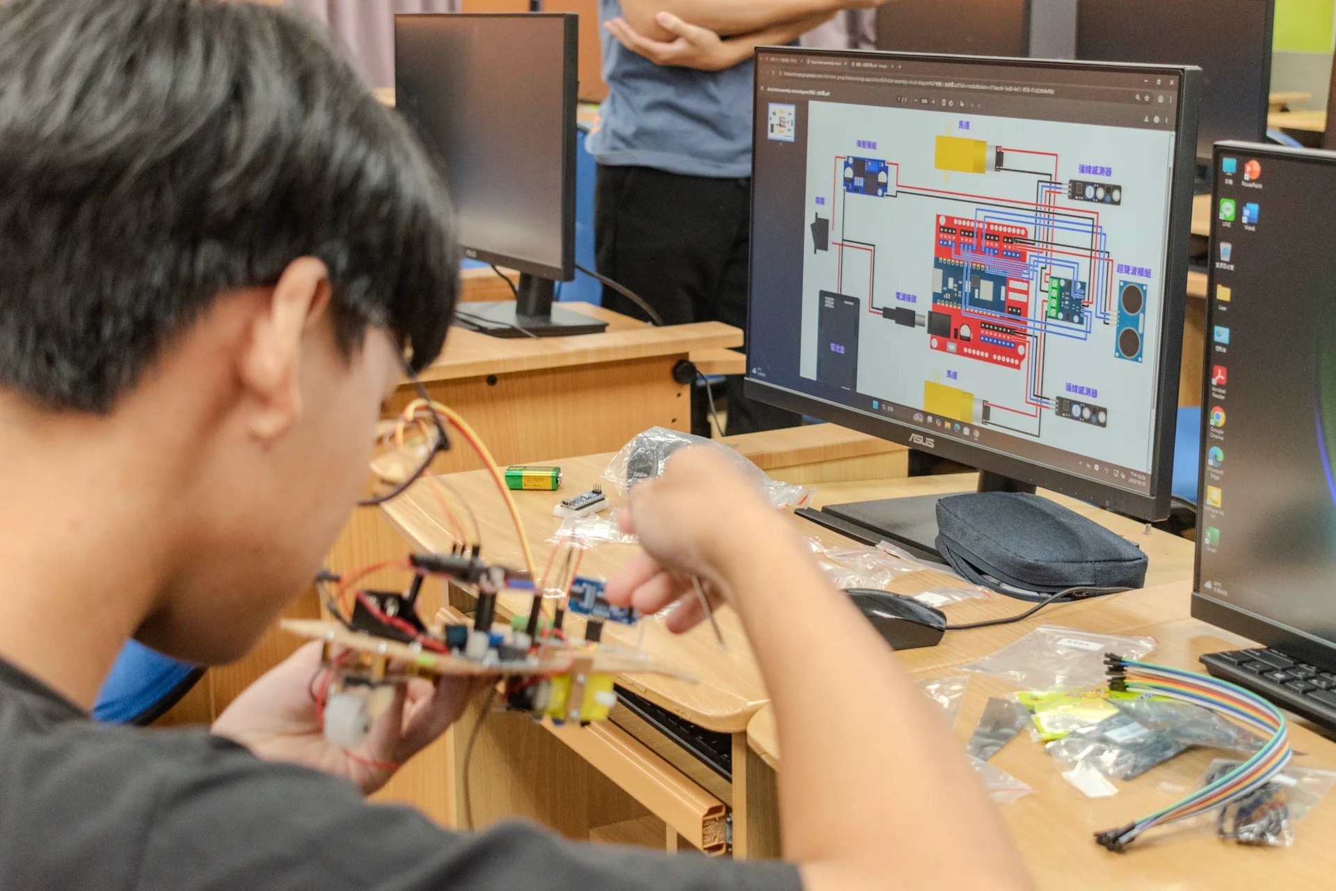 社員正在對照著電路圖組裝線路